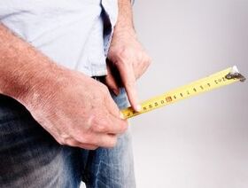 un homme mesure la longueur du pénis avant de l'agrandir avec du soda
